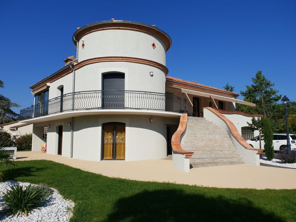 Maison VERTIKAL avec façade arrondie, balcon et escalier extérieur