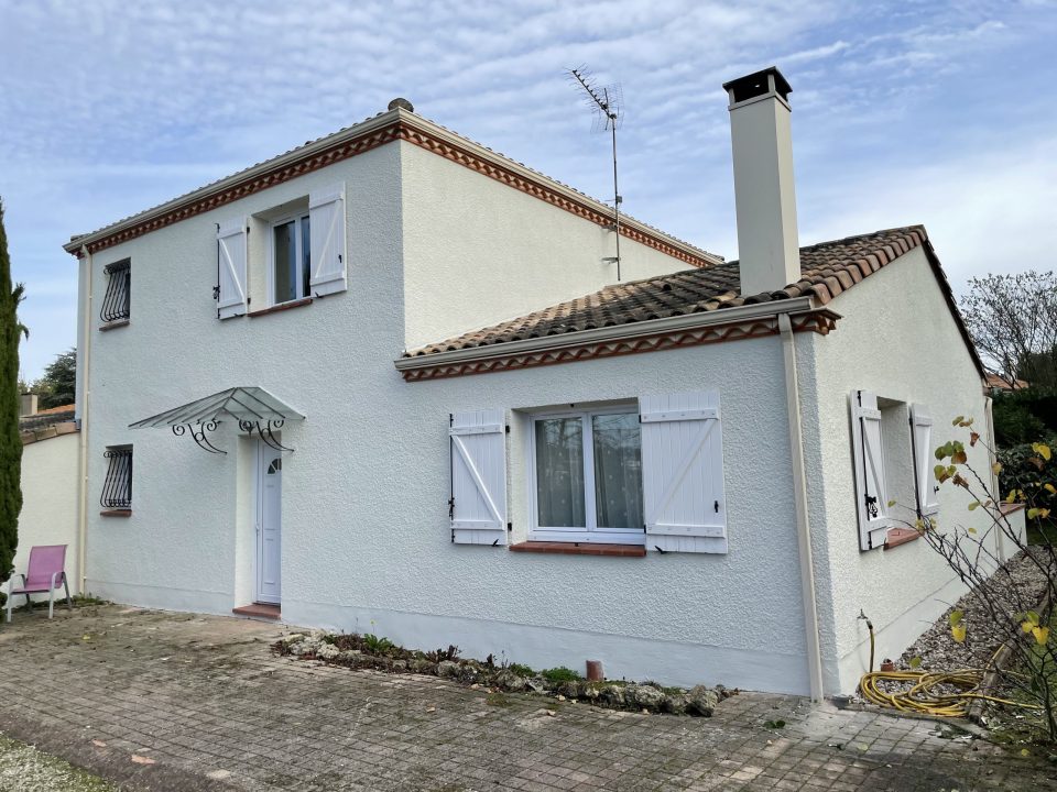 Maison VERTIKAL à façade blanche avec volets et toiture en tuiles