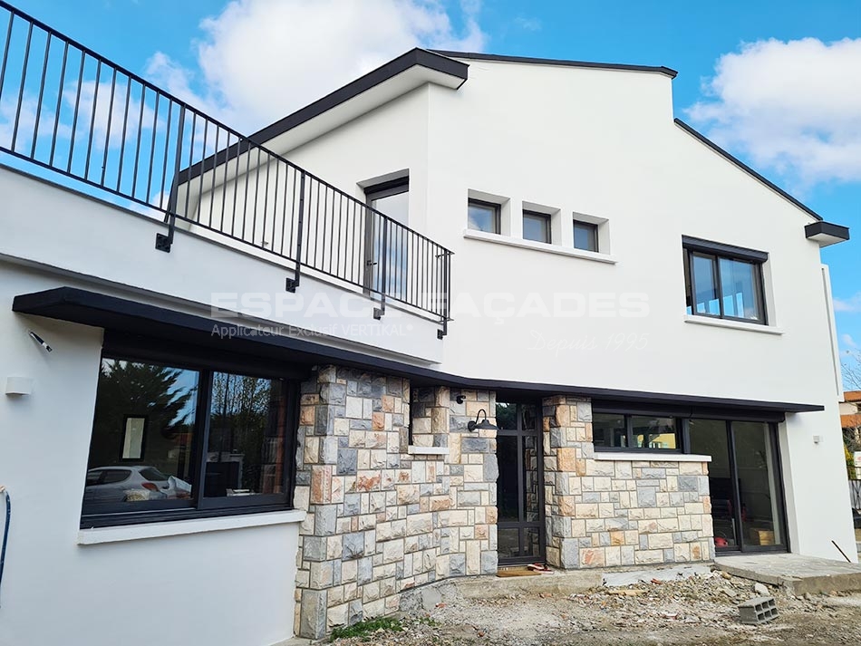 Façade de maison rénovée VERTIKAL avec enduit blanc et parement pierre