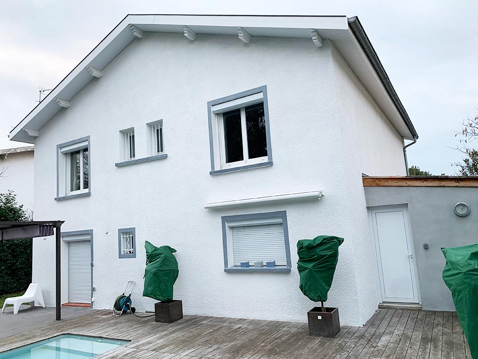 Façade de maison rénovée en blanc avec encadrements gris VERTIKAL