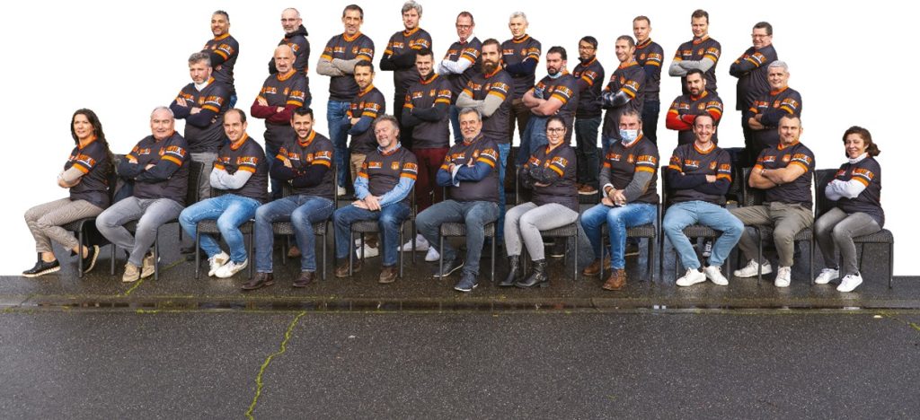 Groupe de personnes portant des vêtements VERTIKAL, souriant et posant ensemble.