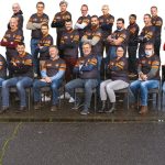 Groupe de personnes portant des vêtements VERTIKAL, souriant et posant ensemble.