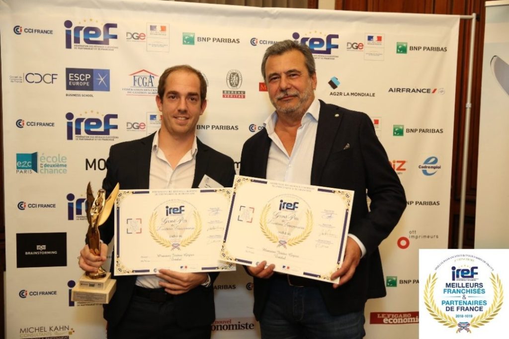 Deux hommes tenant des prix VERTIKAL lors d'une cérémonie.