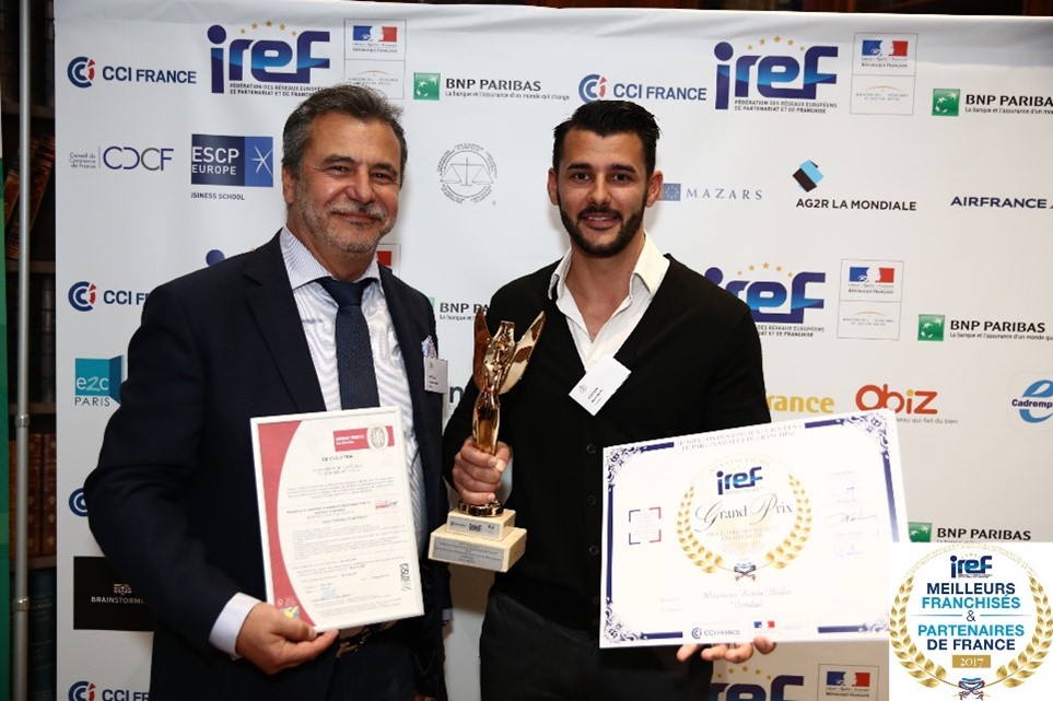 Deux hommes souriants tenant des récompenses, VERTIKAL.