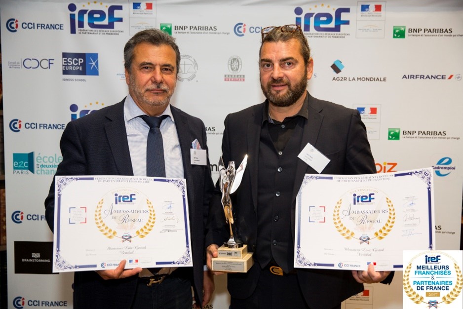 Homme avec trophée et certificat VERTIKAL lors d'un événement IREF.